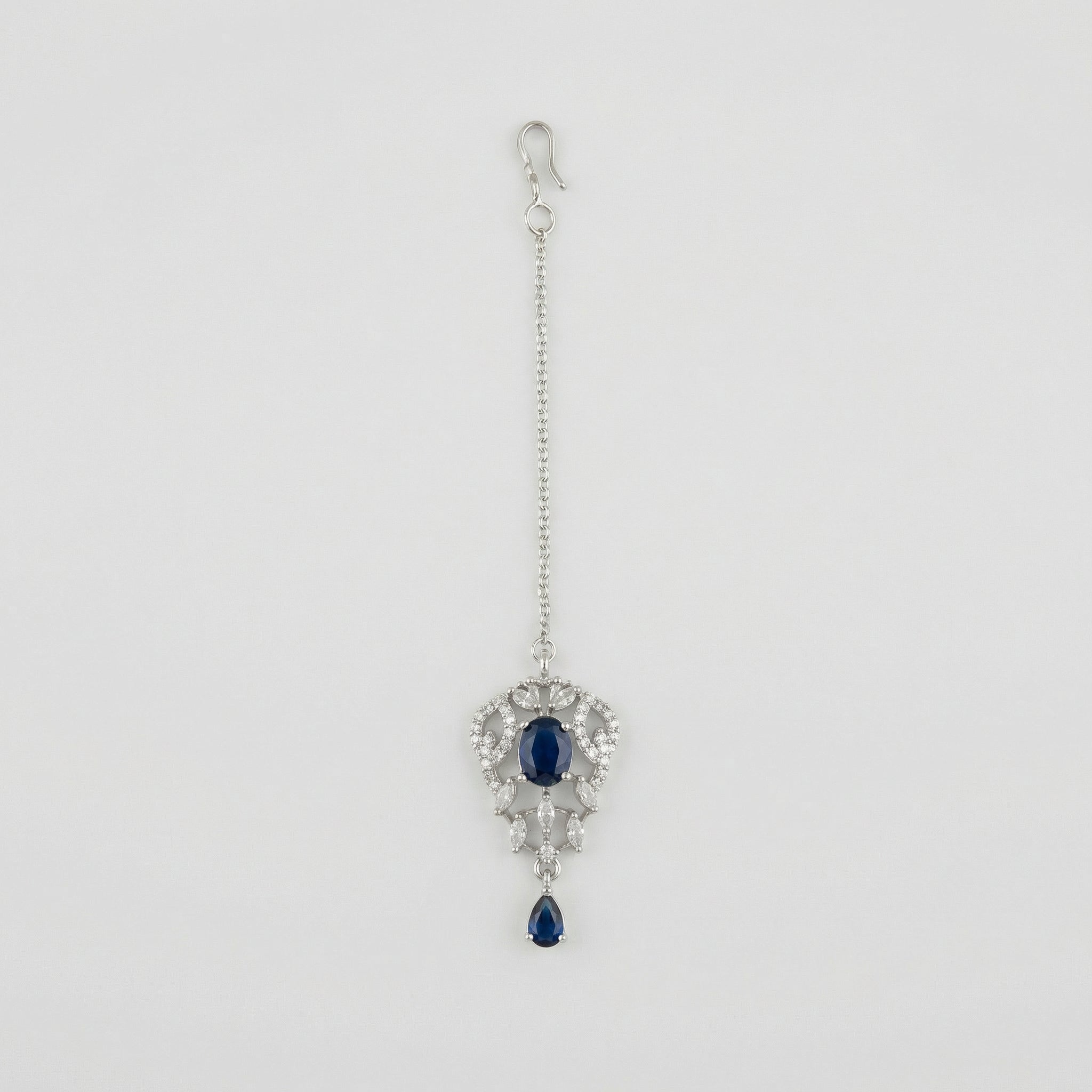 Sapphire Drop Crystal Tikka silver maang tikka with navy blue center stone on gray background