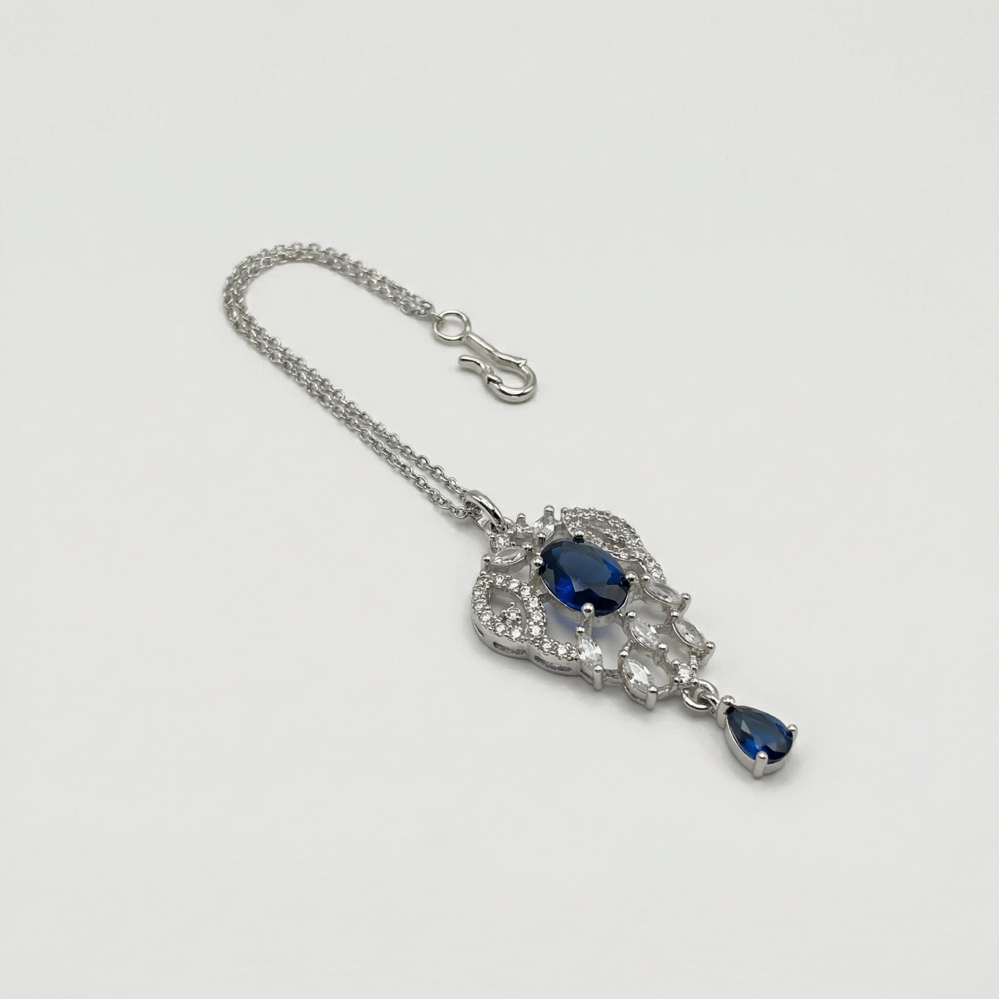 Sapphire Drop Crystal Tikka detail showing oval navy center, clear pavé frame, and navy teardrop drop