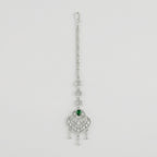 Emerald Grace Tikka silver-tone maang tikka with emerald-green pear center and clear stone frame on gray background