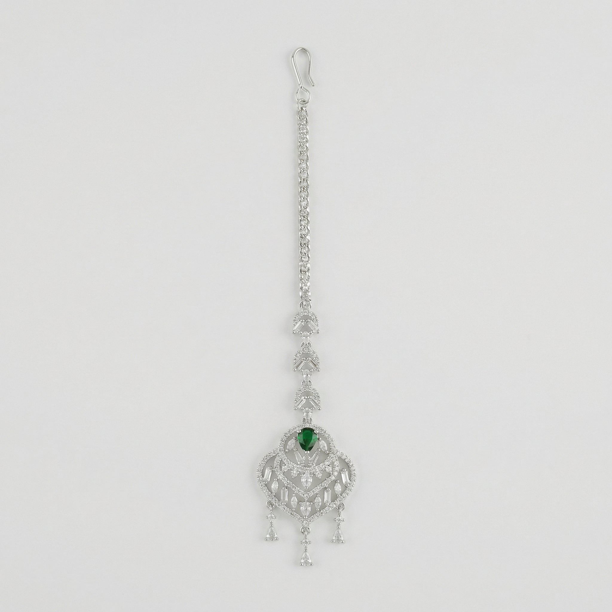 Emerald Grace Tikka silver-tone maang tikka with emerald-green pear center and clear stone frame on gray background