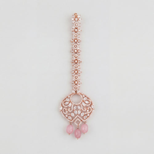 Blush Rosette Drop Tikka rose gold maang tikka with filigree round pendant and pink bead drops on gray background