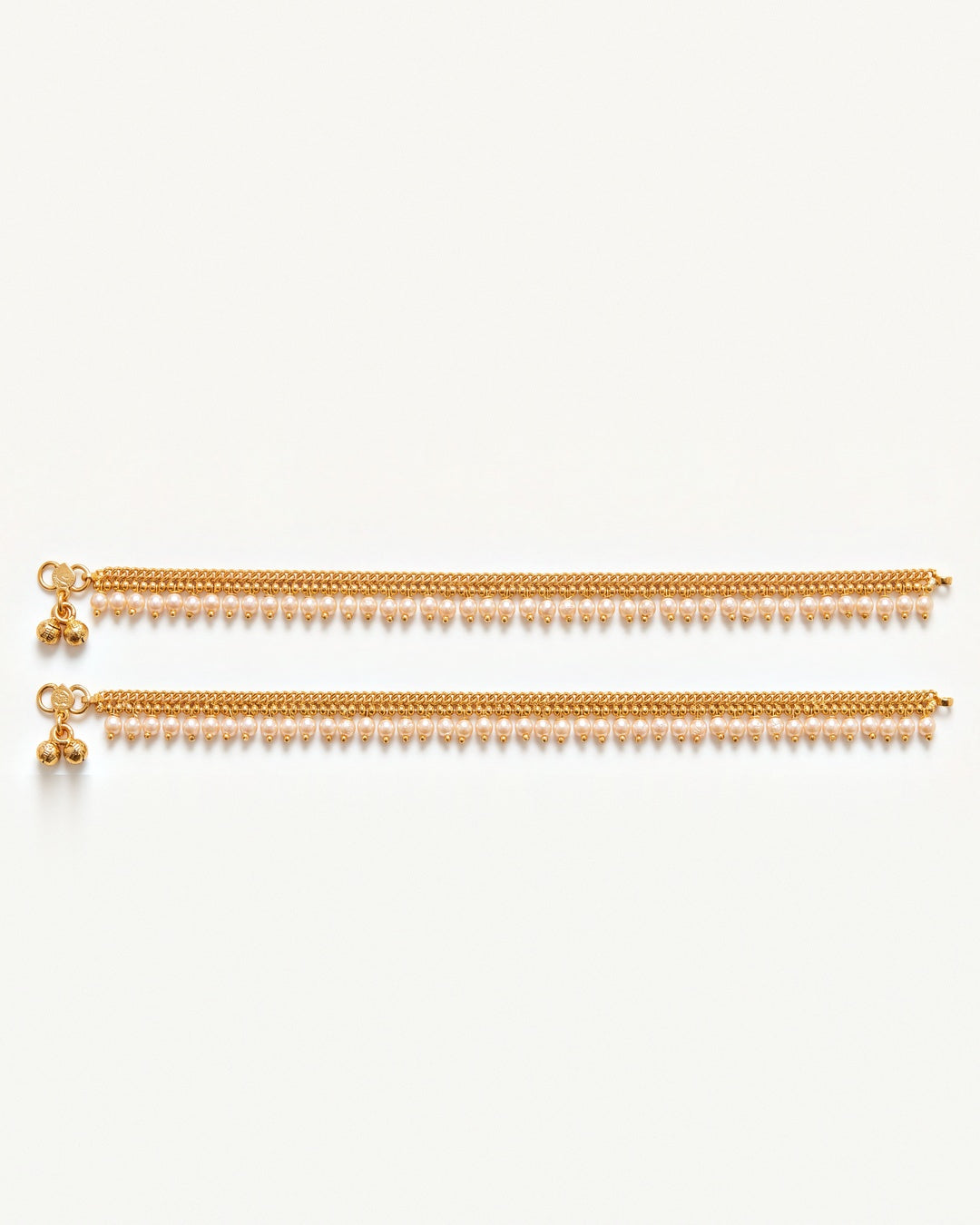 Matching pair of Priya Pearl Anklets laid flat, gold-tone chain with off-white pearl drops and tiny bells