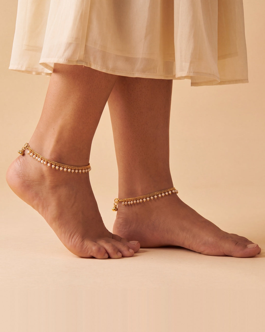 Matching Priya Pearl Anklets worn as a pair, gold-tone chain with off-white pearl drops and tiny bells