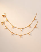 Flat lay of matching Sia Pearl Anklets, gold-tone chain with teardrop cream pearls and bead details