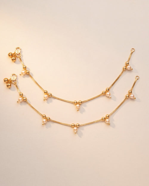 Flat lay of matching Sia Pearl Anklets, gold-tone chain with teardrop cream pearls and bead details