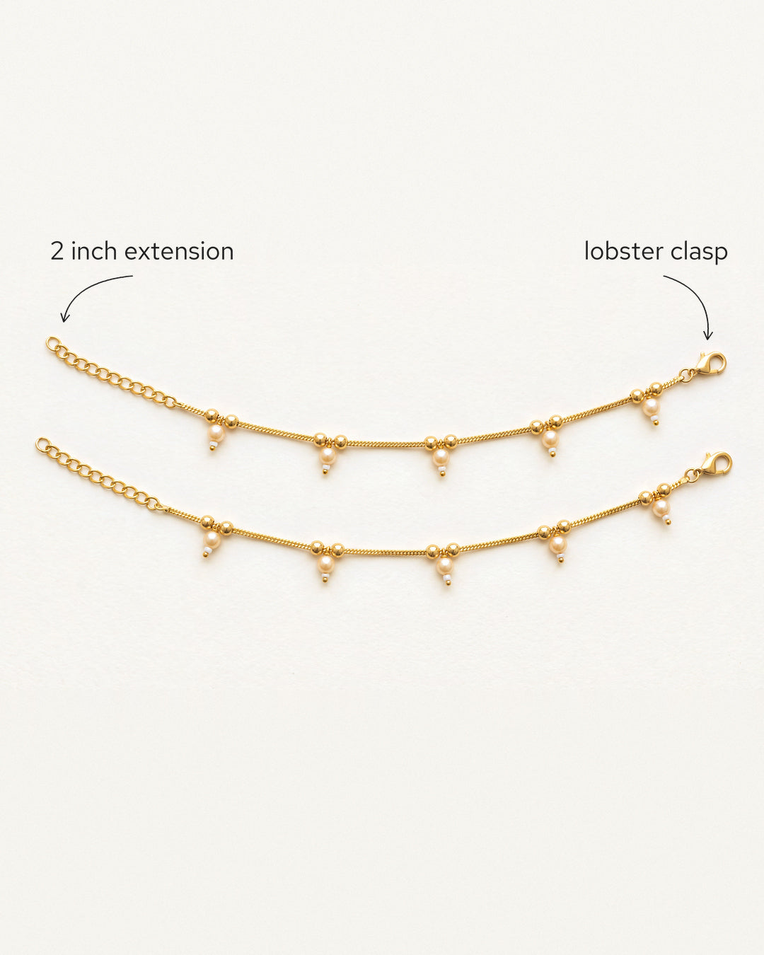 Flat lay of matching Sia Pearl Anklets with labeled 2 inch extension and lobster clasp