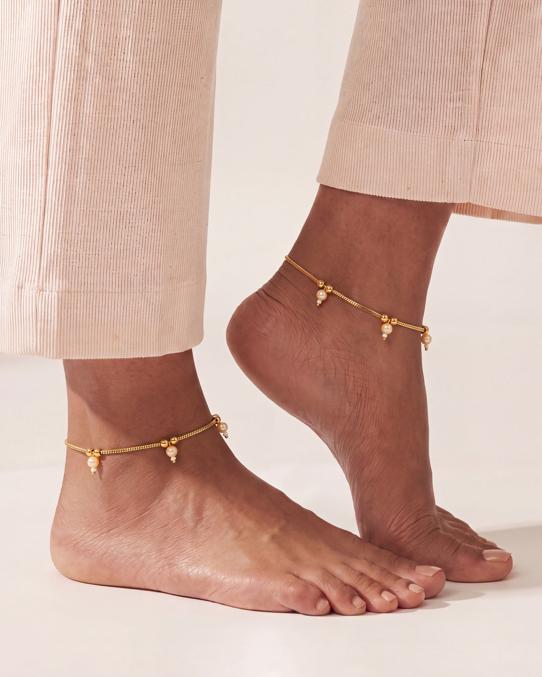 Matching Sia Pearl Anklets worn as a pair, gold-tone chain with cream pearl drops