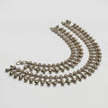 Paisley Drop Anklet pair of oxidized silver kundan payals with rhombus stones and ghungroo fringe on gray background