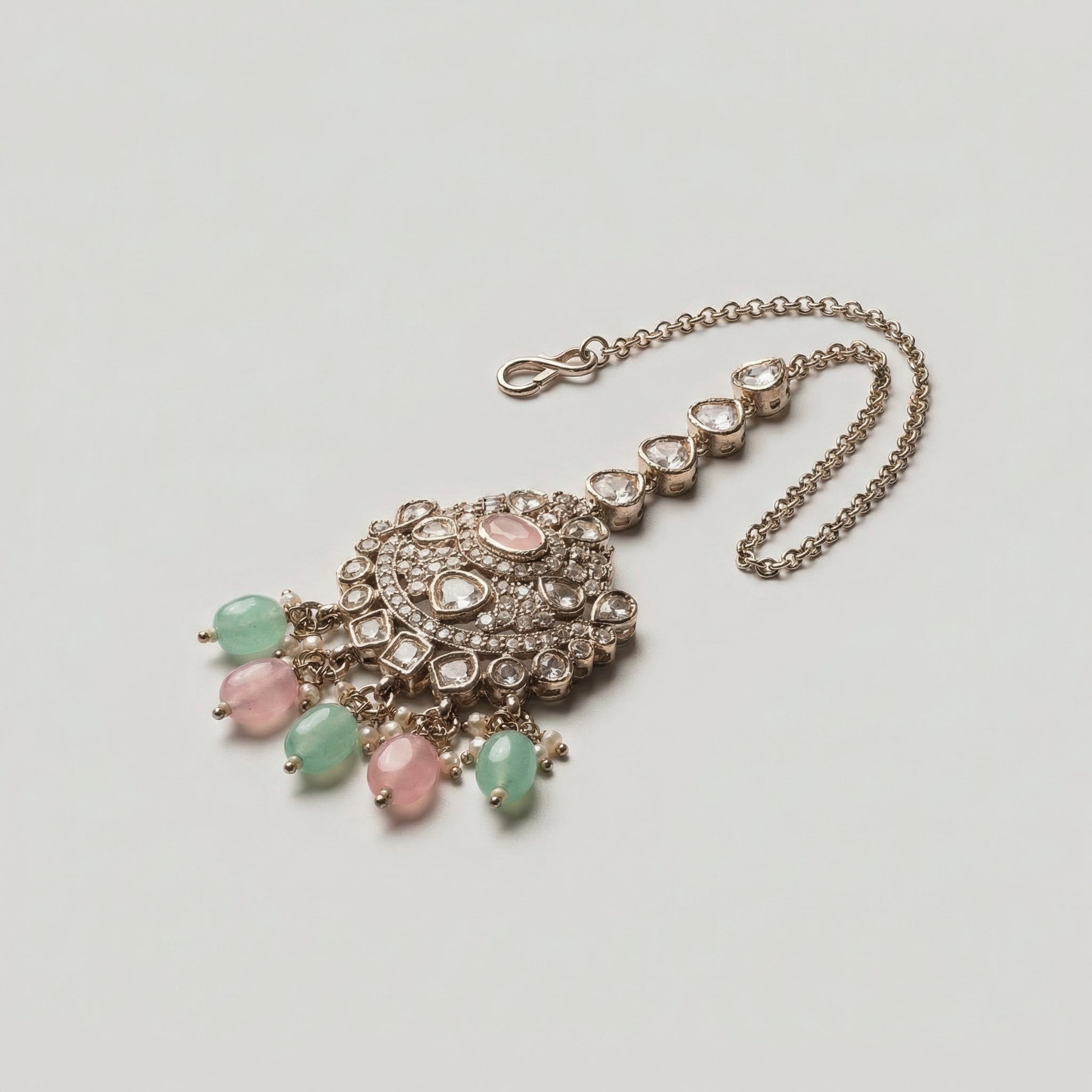 Mridul Tikka detail showing pavé pendant, pink oval stone, and alternating green pink bead drops