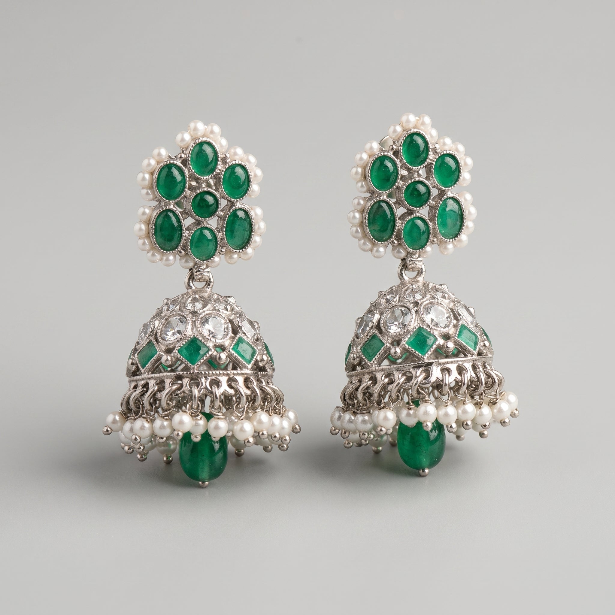Rani Emerald Jhumka Earrings detail showing green cabochon stud, engraved bell, and pearl and emerald drops