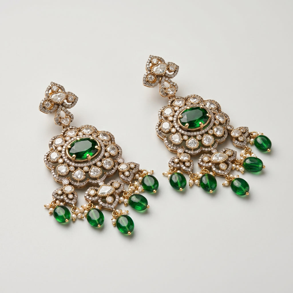 Rani Drop Earrings detail showing emerald-green oval center, pavé scalloped border, and green teardrop pearl fringe