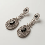 Zara Onyx Earrings detail showing oval black onyx stones, marquise crystal floral link, and pavé lace filigree