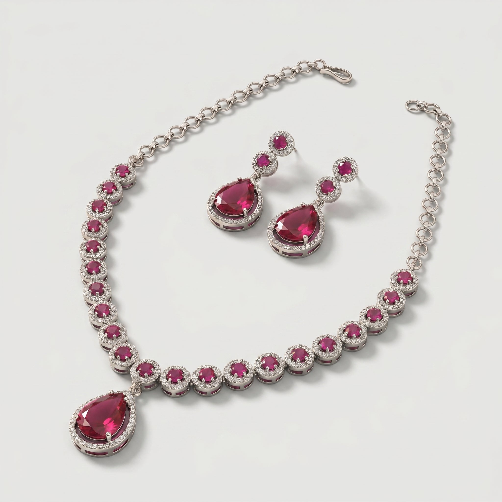 Aira Ruby Necklace Set detail showing halo-set round rubies and pear-cut drop pendant