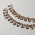Antique Zircon Anklet pair of oxidized silver-tone payals with pink teardrop stones and ghungroo bells on gray background