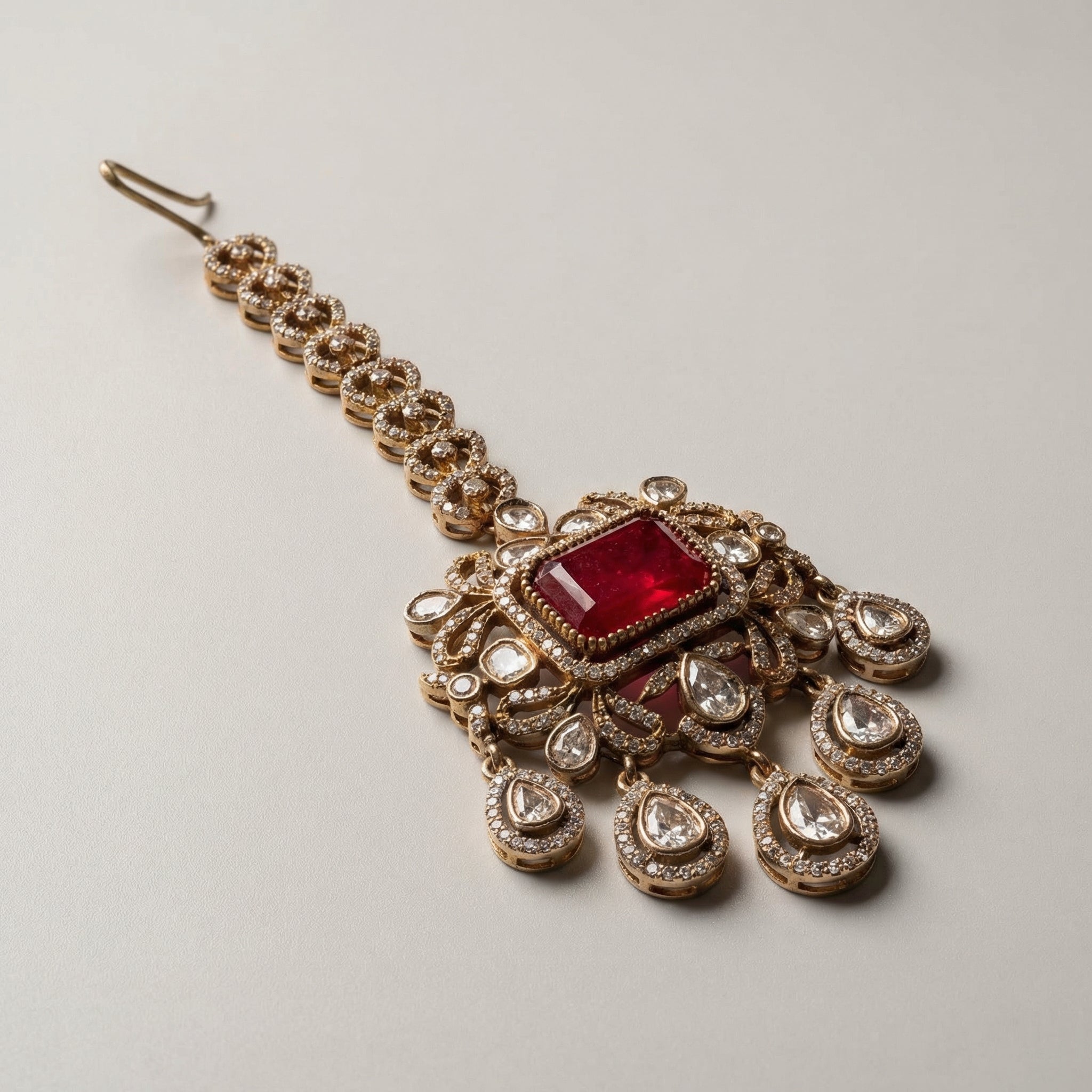 Kundan Ruby Tikka detail showing crystal link chain, rectangular red stone, and teardrop fringe
