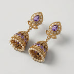 Amethyst Jhumka Earrings gold-tone bell jhumkas with purple teardrop stones and pearl fringe on gray background