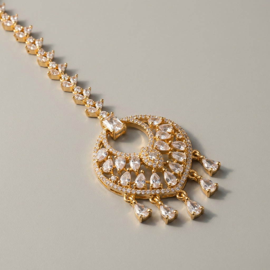 Amala Zircon Tikka detail showing emerald-cut connector, pavé medallion, and five pear crystal dangles