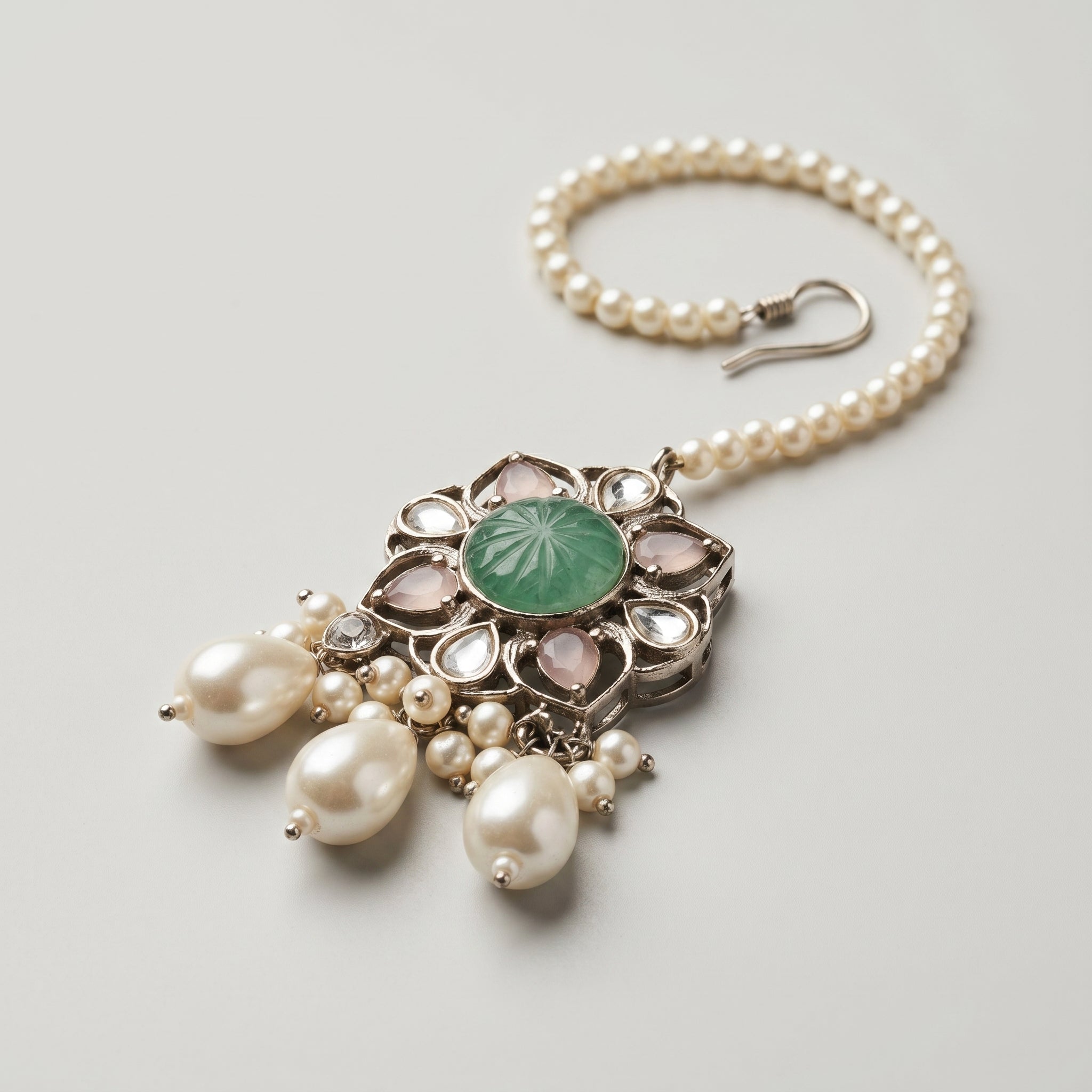 Firozi Pearl Tikka detail showing carved green floral pendant with pink teardrop stones and pearl dangles