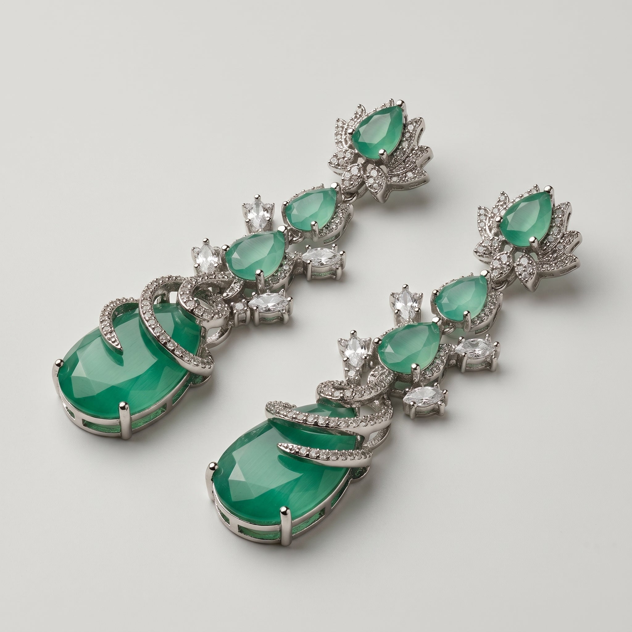 Sia Vine Earrings detail showing lotus floral stud, chatoyant green pear stones, and spiral pavé-wrapped bottom drop