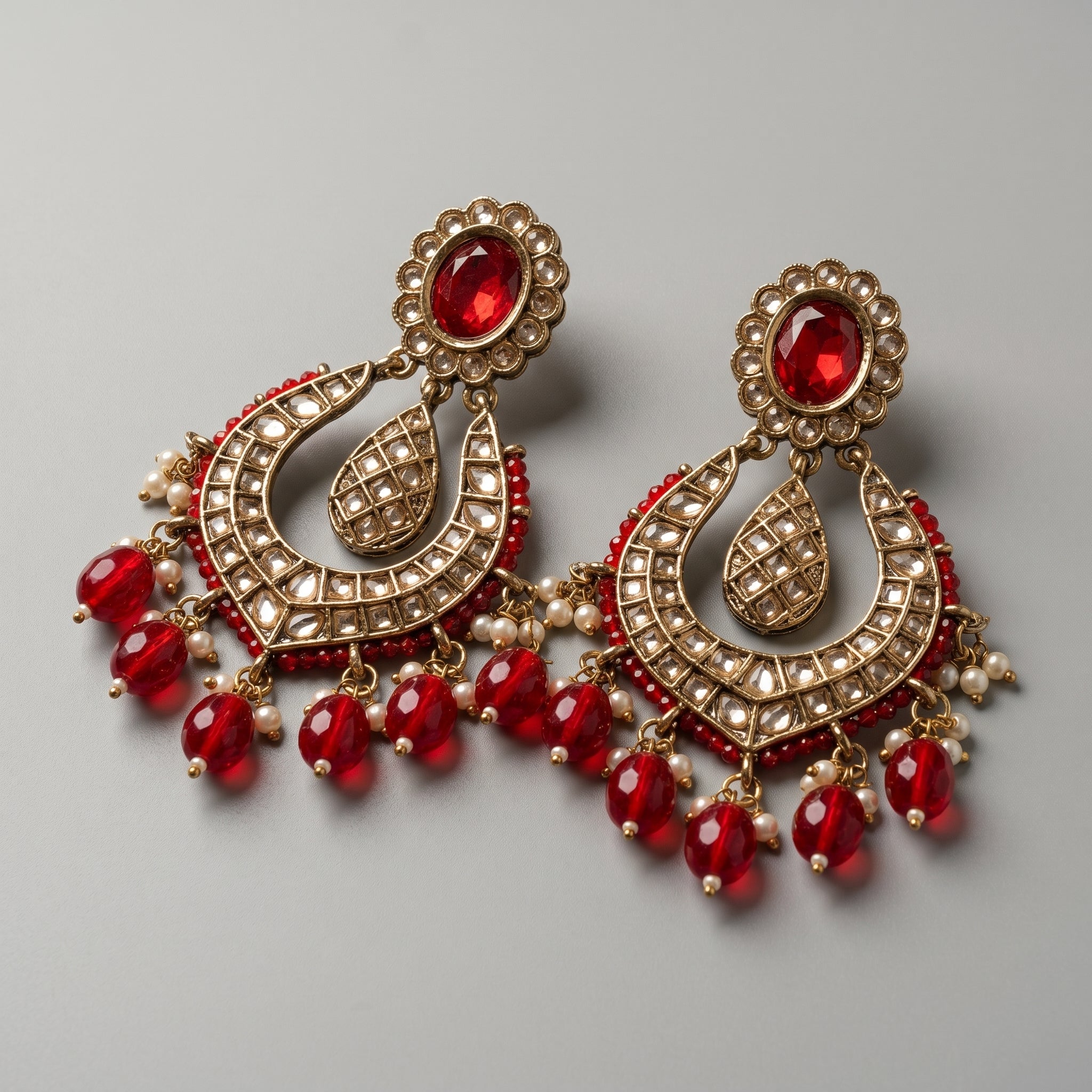 Jadau Ruby Earrings detail showing red oval stud kundan grid crescent and red bead pearl drops