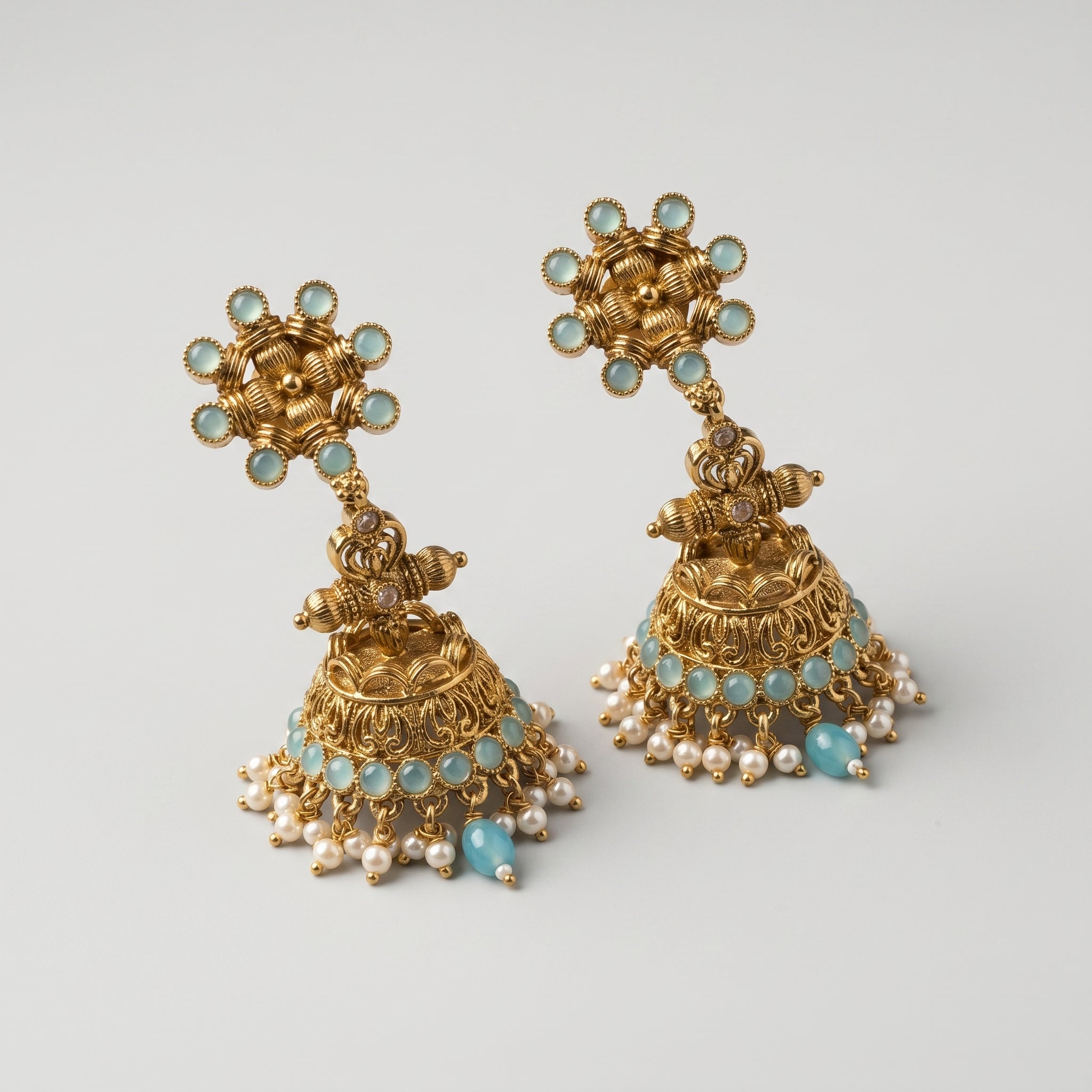 Tara Mint Earrings detail showing sunburst aqua stud, filigree bell, and pearl border