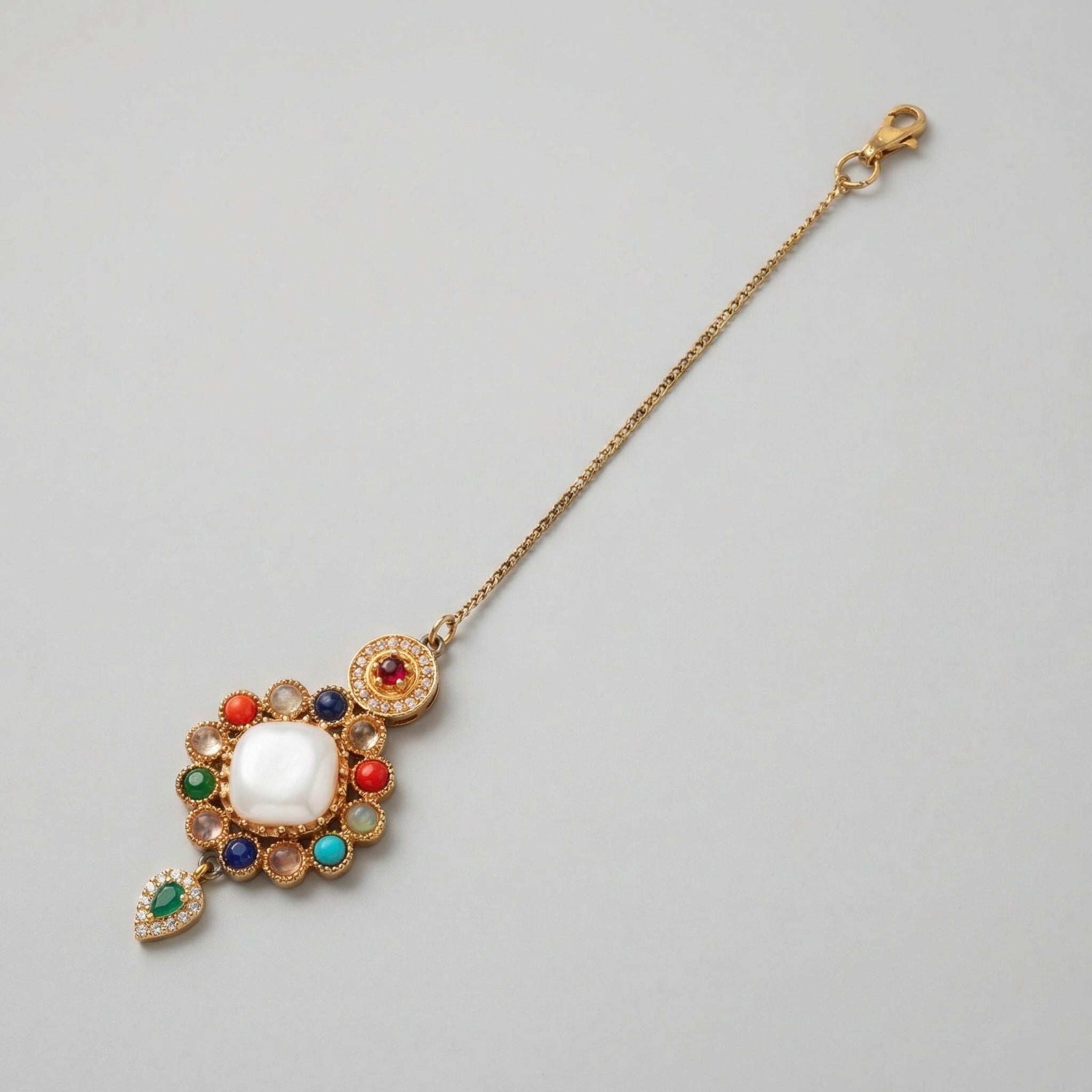 Rangoli Moti Tikka detail showing white center cabochon, colored stone ring, and green drop