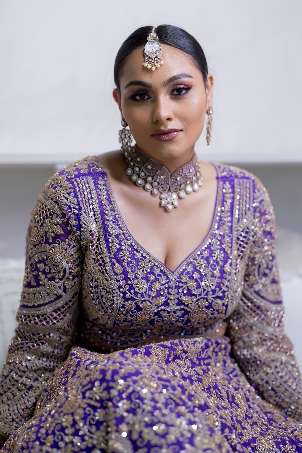 Model wearing Kiian jewelry with a purple outfit